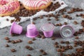 Espresso pink plastic capsules with foil and coffee beans and sweet donuts on gray concrete background