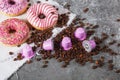 Espresso pink plastic capsules with foil and coffee beans and sweet donuts on gray concrete background