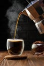 espresso pouring from geyser coffee maker into glass cup on black background Royalty Free Stock Photo