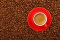 Espresso in red cup with saucer on coffee beans Royalty Free Stock Photo