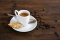 Espresso in a small white coffee cup, spoon and roasted beans on a dark rustic wooden table, copy space, selected focus Royalty Free Stock Photo