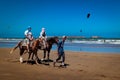 Tourists take a horse ride on the beach