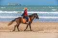 ESSAOUIRA/MOROCCO - MARCH 13, 2014: Young woman rides horse along the ocean