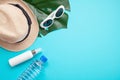 Essential accessories for summer heat: sunglasses, hat, sunscreen, bottle of water. Flat lay, top view