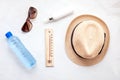 Essential accessories for summer heat: sunglasses, hat, sunscreen, bottle of water. Flat lay, top view