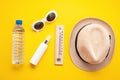 Essential accessories for summer heat: sunglasses, hat, sunscreen, bottle of water. Flat lay, top view