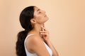 Essential Beauty. Young indian woman touching her soft flawless skin on neck Royalty Free Stock Photo