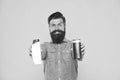 Essential for good hygiene. Hipster hold gel and shampoo bottles. Bearded man with hygiene products. Cosmetics and Royalty Free Stock Photo