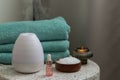 Essential oil aroma diffuser humidifier diffusing water articles in the air. Spa and health care concept. Epsom salt, terry towels