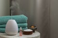 Essential oil aroma diffuser humidifier diffusing water articles in the air. Spa and health care concept. Epsom salt, terry towels