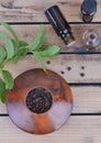 Essential oil in bottle and fresh leaf of mint with pepper in bowl