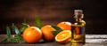 Essential oil bottle next to oranges on wooden table Royalty Free Stock Photo