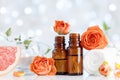 Essential oil bottles with towel, grapefruit and rose flowers on white table. Spa, aromatherapy, wellness, beauty background. Royalty Free Stock Photo