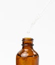 Essential oil falling from the amber glass dropper. Blue bottle of cosmetic oil with a pipette Royalty Free Stock Photo