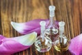 Essential oil in glass bottle with flower petals on wooden background. Beauty treatment. Spa concept. Selective focus. Royalty Free Stock Photo