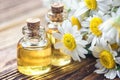 Essential oil in glass bottle with fresh chamomile flowers, beauty treatment. Spa concept. Selective focus. Fragrant oil of chamom Royalty Free Stock Photo