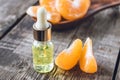 Essential oil with mandarin and slices of ripe yellow mandarin lie on a wooden table Royalty Free Stock Photo