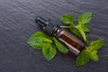 Essential oil of peppermint on a dark stone background