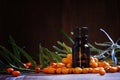 Essential oil of sea buckthorn, small brown bottle and scattered