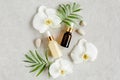 Essential oil, vegetable extract, serum, hyaluronic acid, facial cream, tropic palm leaves on gray marble background