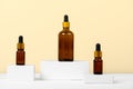 Essential oils on a beige background on white podiums, mockup. Cosmetic medical beauty product in brown glass bottles with a