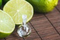 Essential oils in glass bottle with fresh, juicy, ripe limes. Beauty treatment. Spa concept. Selective focus. Small bottles of per Royalty Free Stock Photo