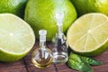 Essential oils in glass bottle with fresh, juicy, ripe limes. Beauty treatment. Spa concept. Selective focus. Small bottles of per Royalty Free Stock Photo