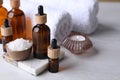 Essential oils, sea salt, candle and towels on white table, closeup Royalty Free Stock Photo