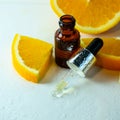 Essential orange oil in a bottle, pieces of fresh fruit. Natural flavors. Citrus oil for skin care, spa, wellness, massage Royalty Free Stock Photo