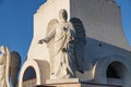 Statue of an angel holding a candlestick in a sculptural composition at the foot of the statue of Christ