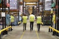 ESSEX, ENGLAND- MAR 13 2016: Staff in reflective vests walking away from camera in a supermarket distribution warehouse Royalty Free Stock Photo