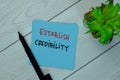 Establish Credibility write on sticky notes isolated on Wooden Table