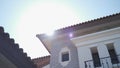 Established shot, sunlight flare from sky to roof of luxury real estate house. lens flare light from western home in sunny day