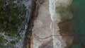 Establisher shot of waves of beautiful clean and clear sea touching and hitting the rocks and wall during day at Tulum