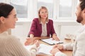 Real estate agent and couple signing contract at table in new apartment Royalty Free Stock Photo