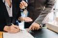 Estate agent giving house keys to man and sign agreement in office Royalty Free Stock Photo