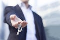 Real estate agent giving keys with buildings background Royalty Free Stock Photo