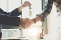 Estate agent shaking hands with his customer after contract signature, Contract document and house model on wooden desk Royalty Free Stock Photo