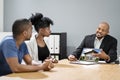 Estate Agent Showing House On Laptop To Young Couple Sitting Royalty Free Stock Photo