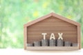 Estate tax,Model house with stack of coins money and tax word on green background,Business investment and Property tax concept Royalty Free Stock Photo