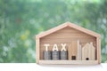 Estate tax,Model house with stack of coins money and tax word on green background,Business investment and Property tax concept Royalty Free Stock Photo