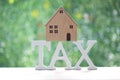 Estate tax,Model house on tax word on natural green background,Business investment and Property tax concept Royalty Free Stock Photo