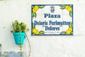 Architectural detail, colorful street sign and flowerpots in the town of Estepona, located on