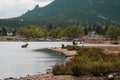 Tourists get too close taking photos of an elk swimming in Lake Estes