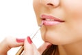 Esthetician apply lipstick on female lips closeup