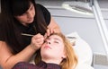 Esthetician Grooming Eyebrows of Female Client