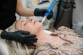 An esthtetician microneedling a spa client as she lies on a table in a health and wellness medical clinic Royalty Free Stock Photo