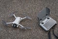 Estonia, Tallinn May 25, 2023. Dji mini 3 pro drone with remote control with RC screen on an asphalt road