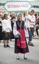 Estonian people in traditional clothing walking the streets of Tallinn