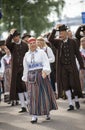 Estonian people in traditional clothing walking the streets of Tallinn